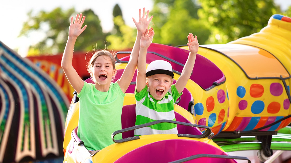 Children enjoying a roller coaster ride at an amusement park.