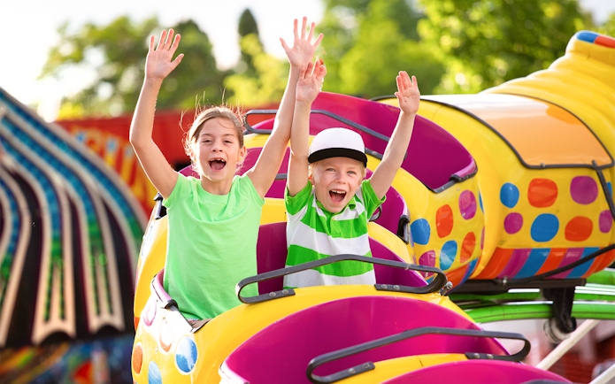 Children enjoying a roller coaster ride at an amusement park.