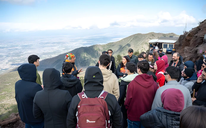 Tour group listening to a guide at Vesuvius National Park near Naples, Italy.
