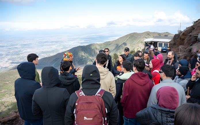 Tour group listening to a guide at Vesuvius National Park near Naples, Italy.