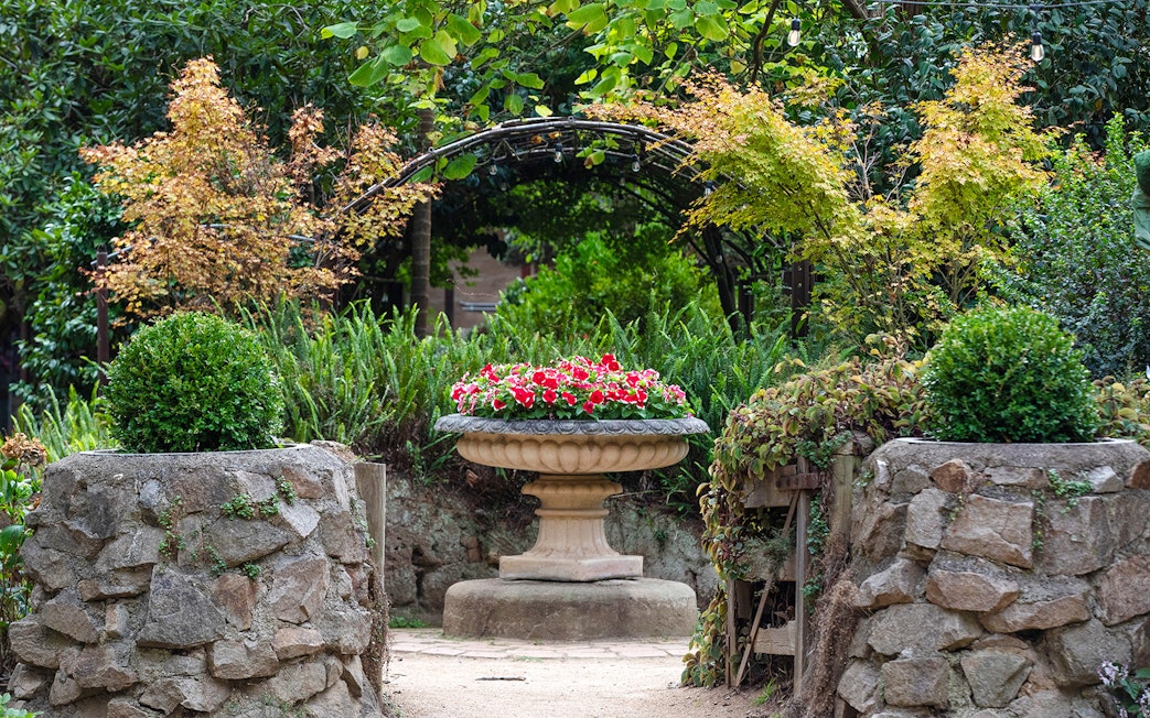 Stone pathway leading to a flower urn in Aschombe Maze & Lavender Gardens.