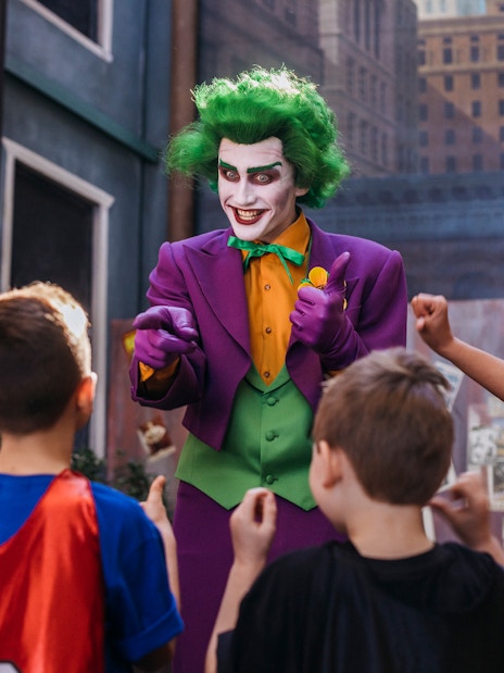 Tourists interact with Joker character at Movie World theme park.