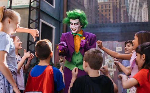 Tourists interact with Joker character at Movie World theme park.