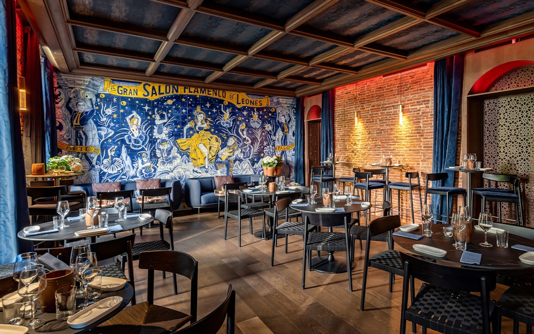 Flamenco De Leones Show venue with mural and dining setup.