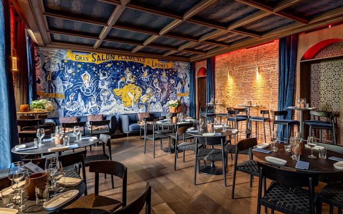 Flamenco De Leones Show venue with mural and dining setup.