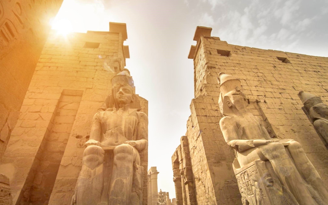 Luxor Temple statues and ancient walls under sunlight, Egypt.