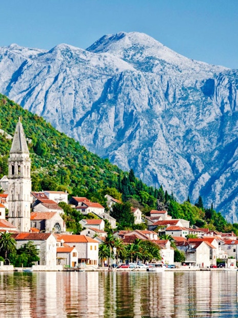 Perast town with historic buildings and mountains in the background.