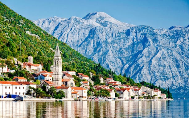 Perast town with historic buildings and mountains in the background.