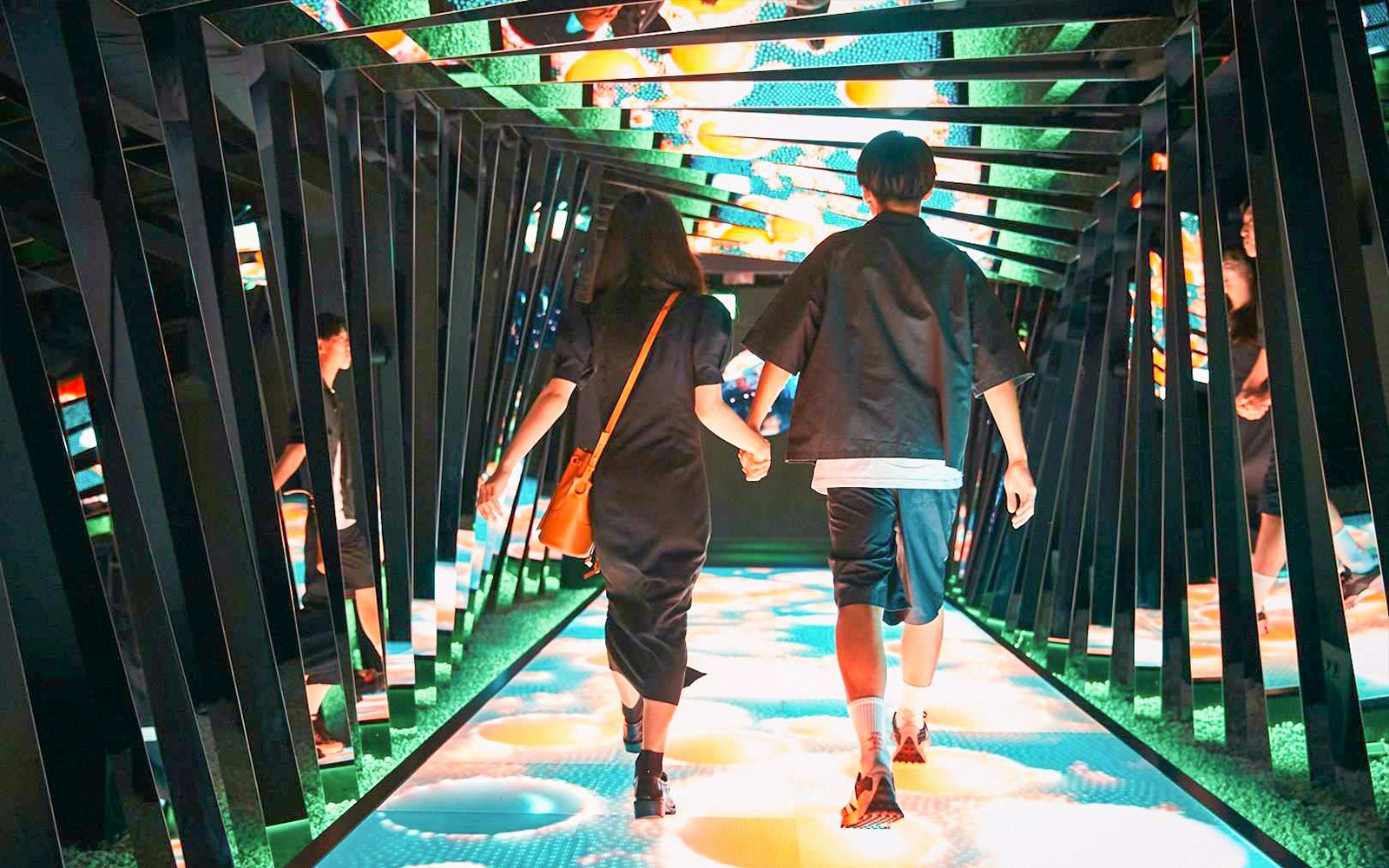 Visitors walking through an illuminated tunnel at RED° TOKYO TOWER.