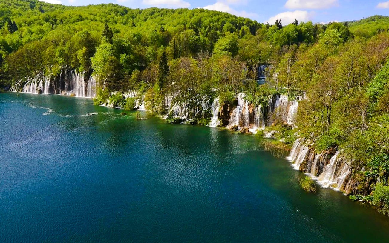 Plitvice Lakes waterfalls surrounded by lush greenery on the Split to Zagreb private transfer route.