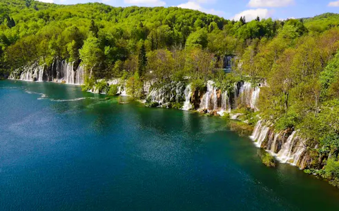 Plitvice Lakes waterfalls surrounded by lush greenery on the Split to Zagreb private transfer route.