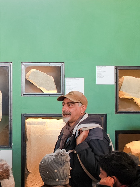 Tour group viewing ancient graffiti at Colosseum exhibit, Rome.