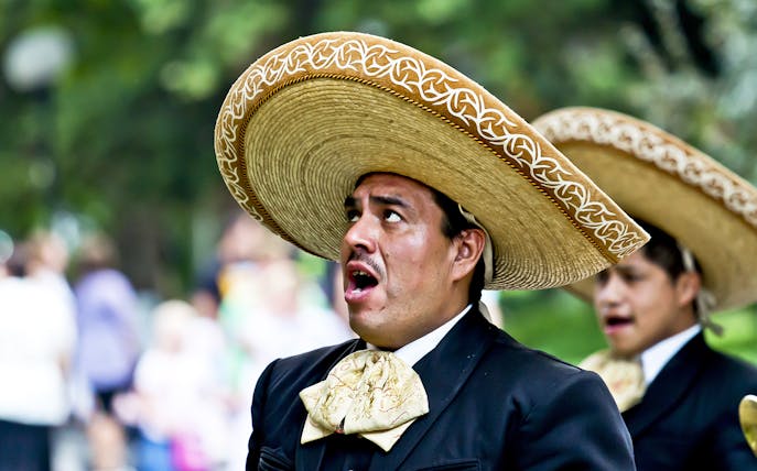 Mariachi singer performing in traditional attire during Mexico City night tour.