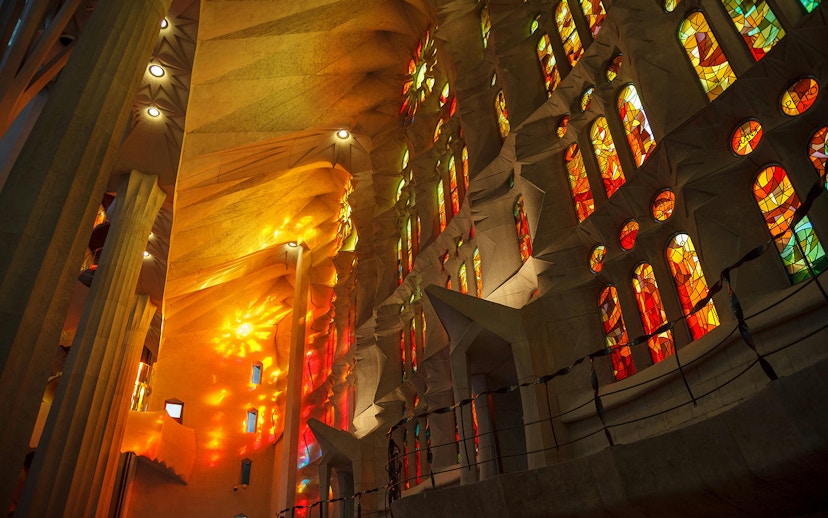 Stained glass windows of Sagrada Familia with vibrant colors illuminating the interior.