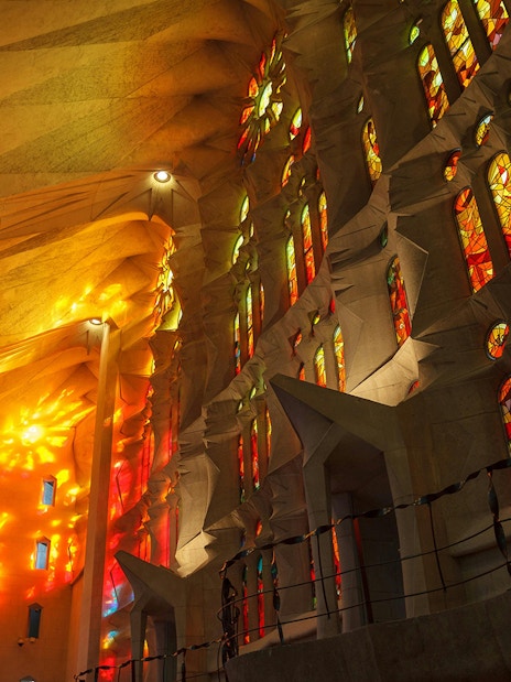 Stained glass windows of Sagrada Familia with vibrant colors illuminating the interior.