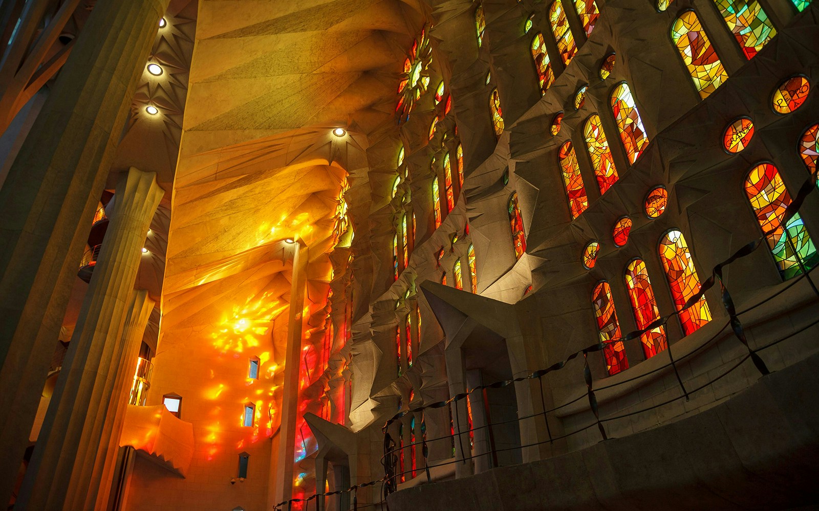 Stained glass windows of Sagrada Familia with vibrant colors illuminating the interior.