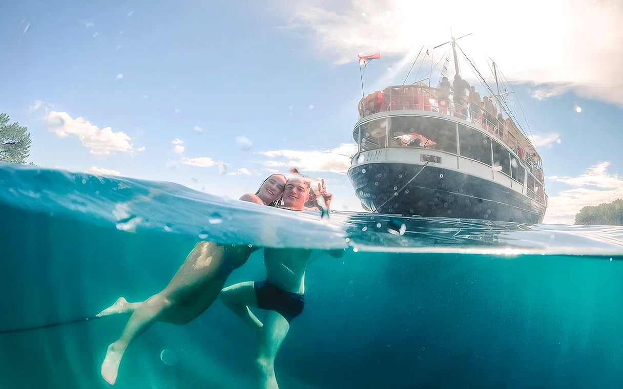 Guests swimming near a boat during Split Party Cruise.