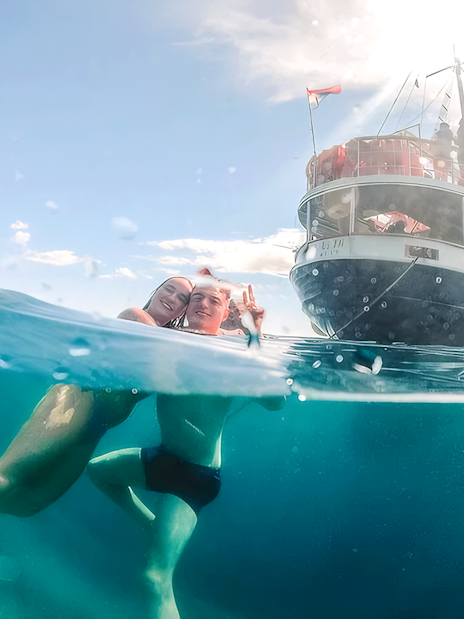 Guests swimming near a boat during Split Party Cruise.
