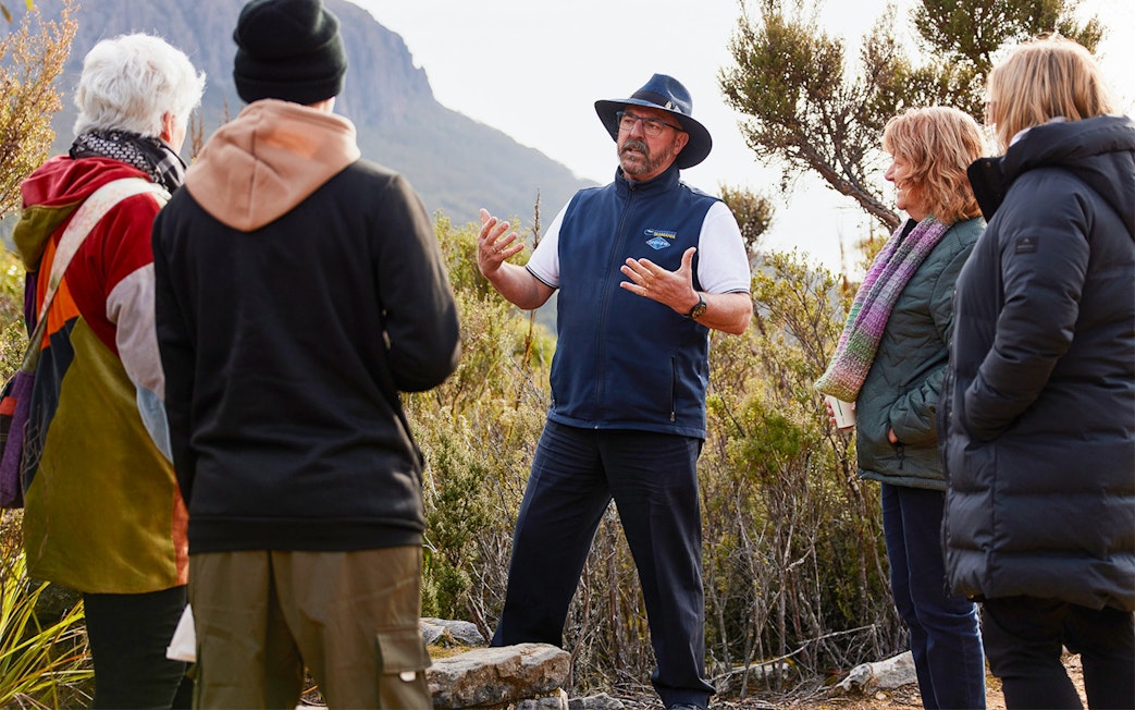 Guide explaining Mt Wellington features to a group of tourists.