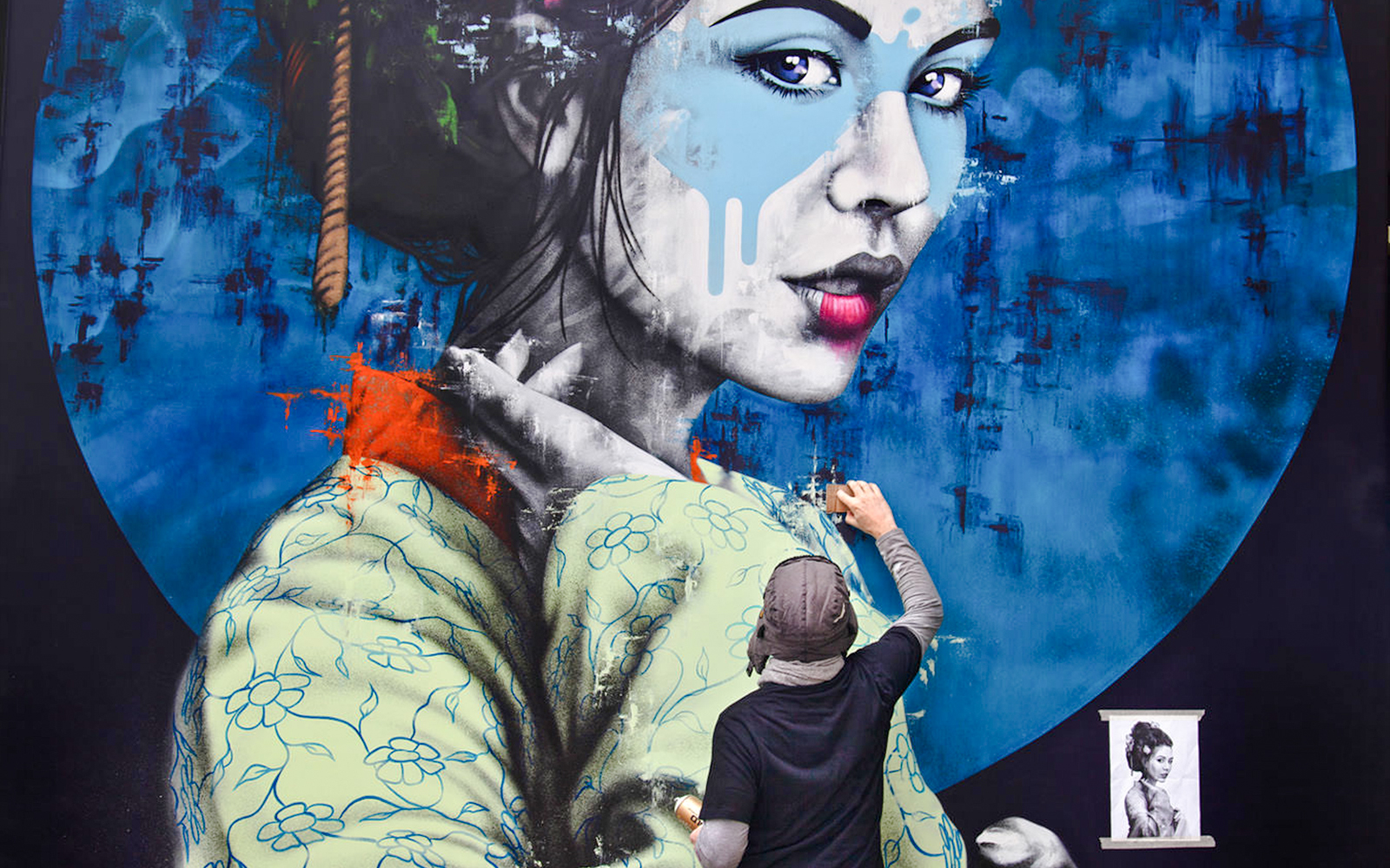 Artist painting a large mural of a woman in traditional attire, titled "Yuansu" by Fin DAC.