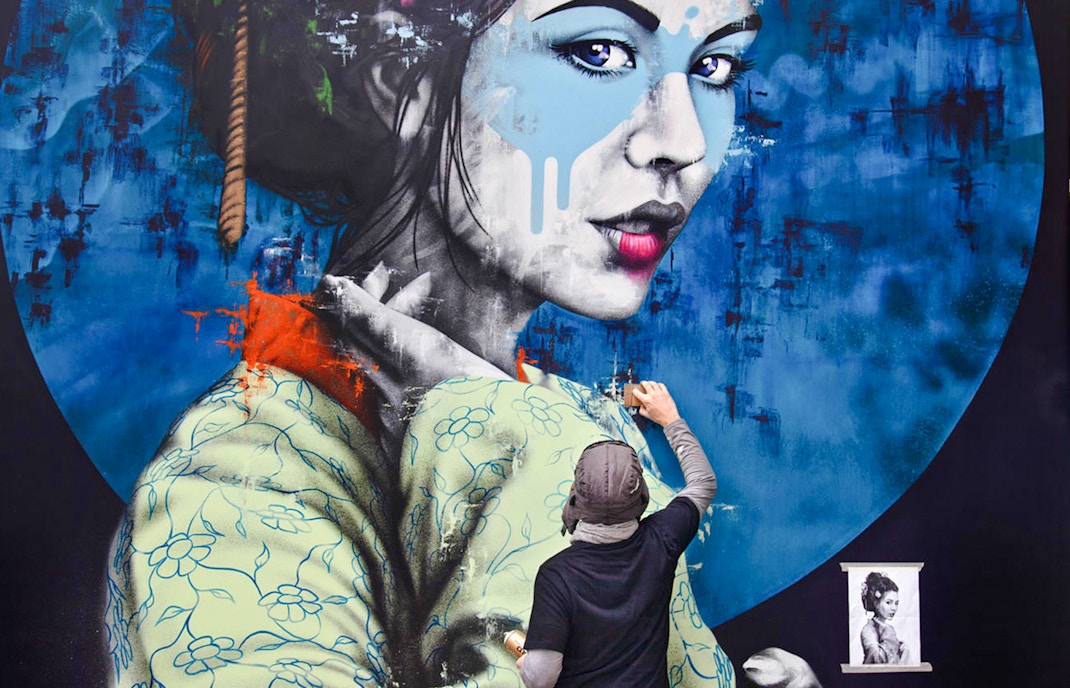 Artist painting a large mural of a woman in traditional attire, titled "Yuansu" by Fin DAC.