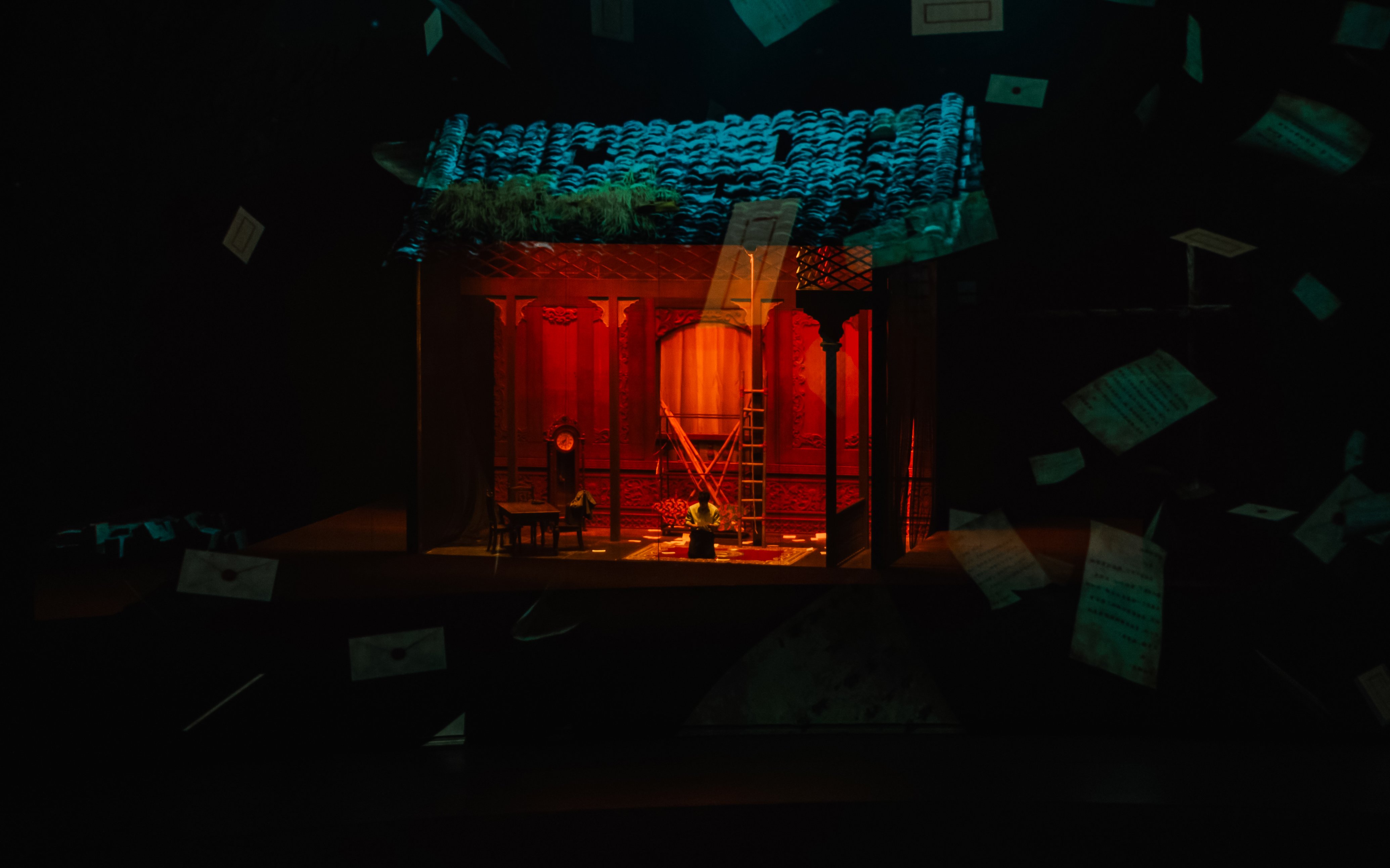 Stage set for "The Legacy of a Generation Show" with red lighting and scattered papers.