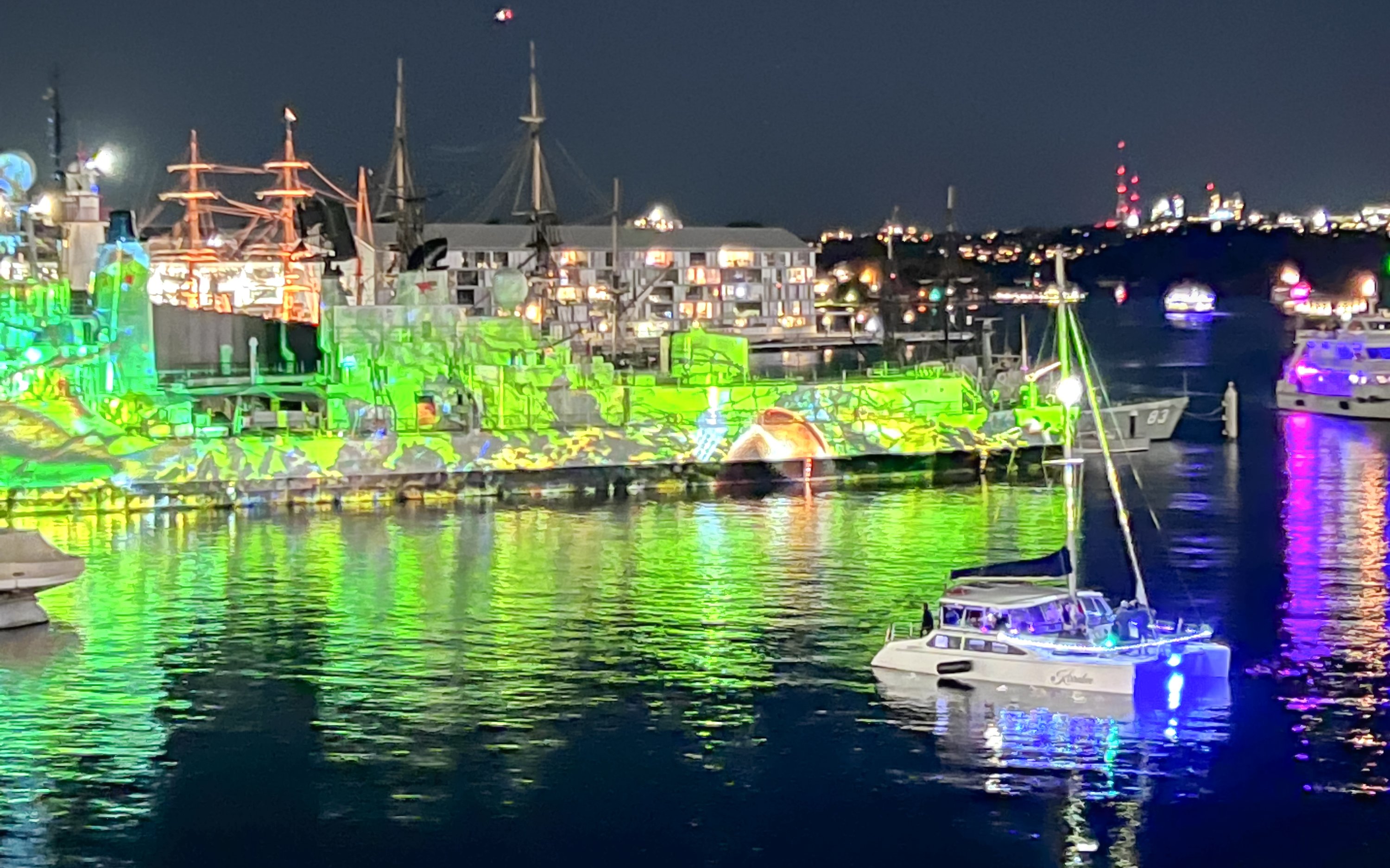 Luxury yacht cruising Sydney Harbour during Vivid Sydney light festival.