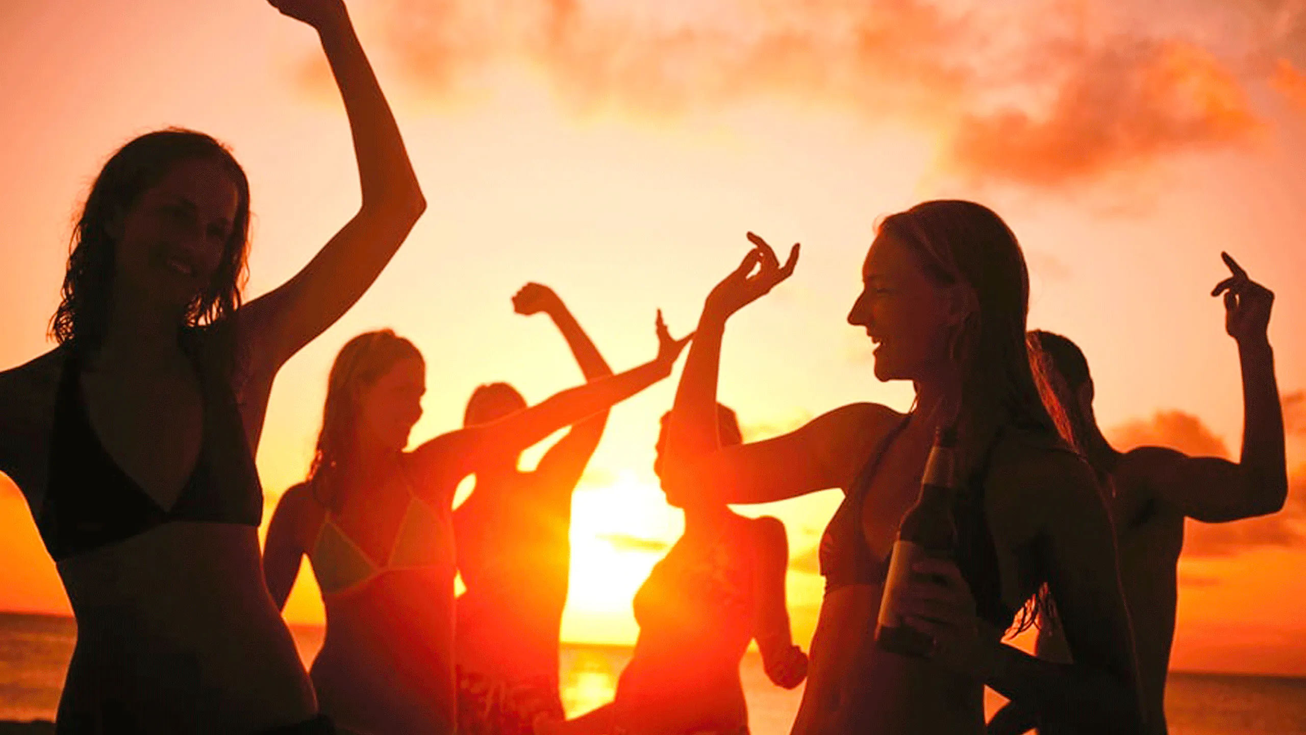 Partygoers dancing at sunset on a boat in Cartagena's Bay.