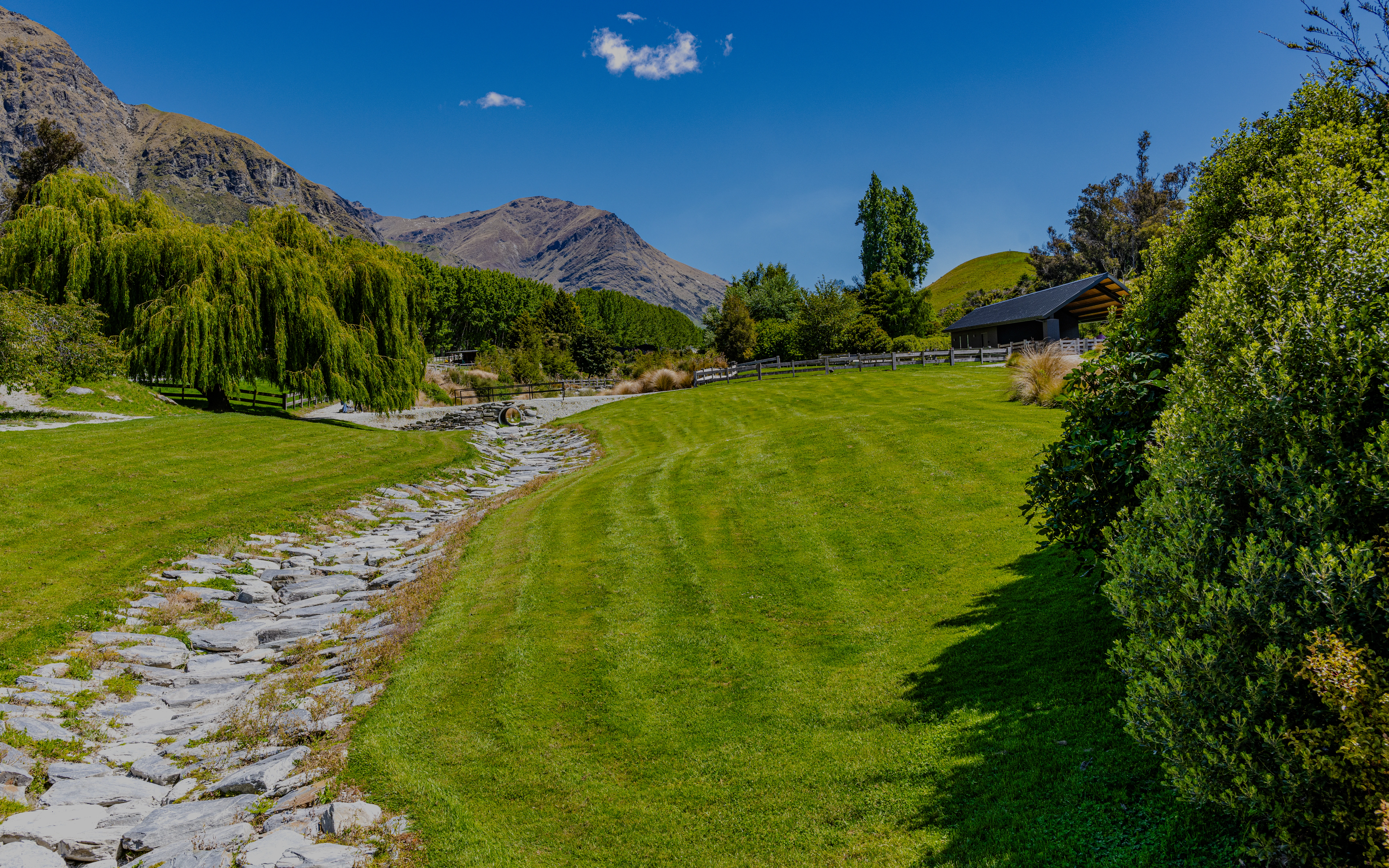 Gardens at Walter Peak High Country Farm with mountain backdrop and lush greenery.