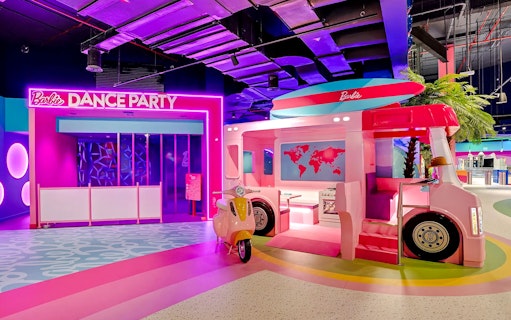 Barbie-themed dance party area with pink bus and scooter at Mission: Play! by Mattel.