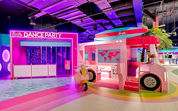 Barbie-themed dance party area with pink bus and scooter at Mission: Play! by Mattel.