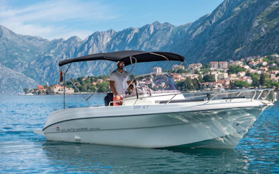 Boat tour near Lady of the Rocks and Perast Old Town with mountainous backdrop.