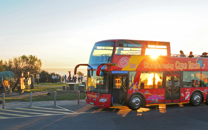 HopOn HopOff bus at sunset point, Cape Town, with tourists enjoying the view.