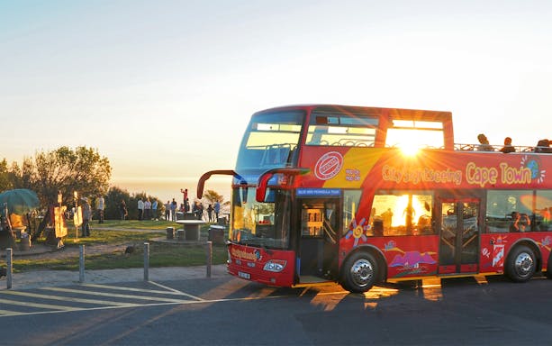 HopOn HopOff bus at sunset point, Cape Town, with tourists enjoying the view.