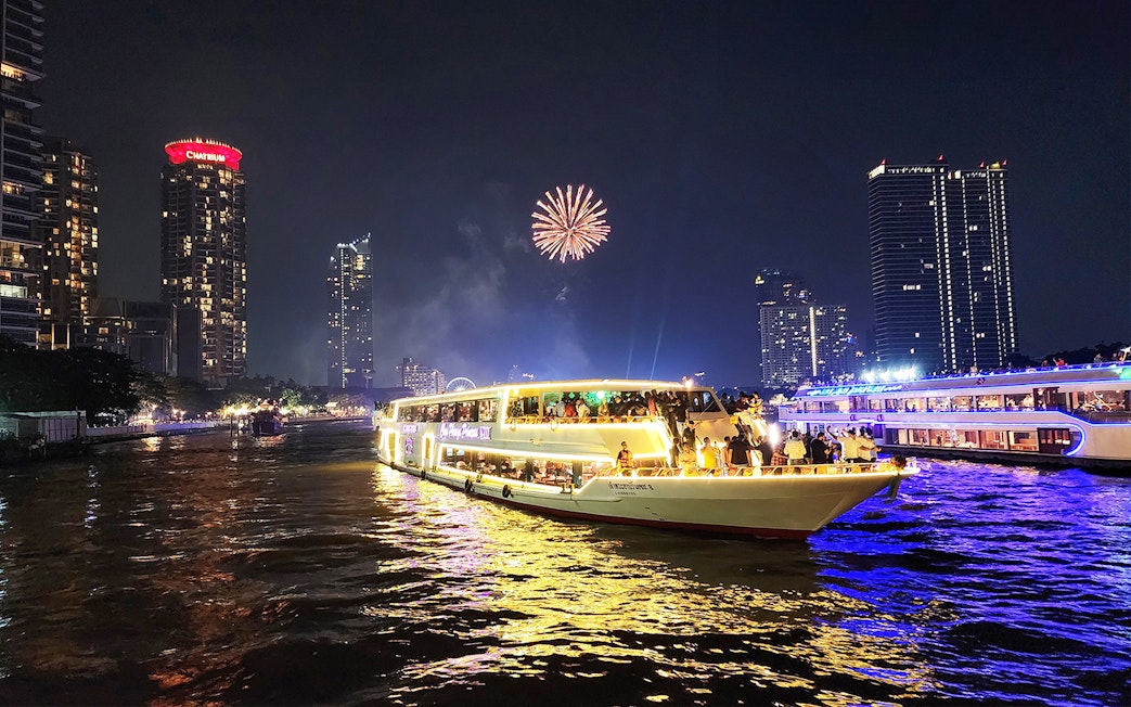 Chao Phraya Princess Cruise with fireworks over Bangkok skyline at night.
