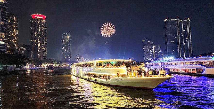 Chao Phraya Princess Cruise with fireworks over Bangkok skyline at night.