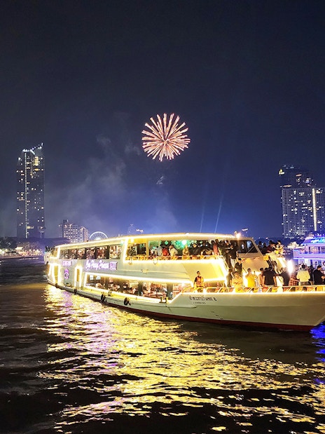 Chao Phraya Princess Cruise with fireworks over Bangkok skyline at night.