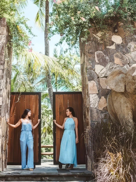 Visitors at the entrance gate of Lombok Wildlife Park, Tanjung, Indonesia, with elephant statues.