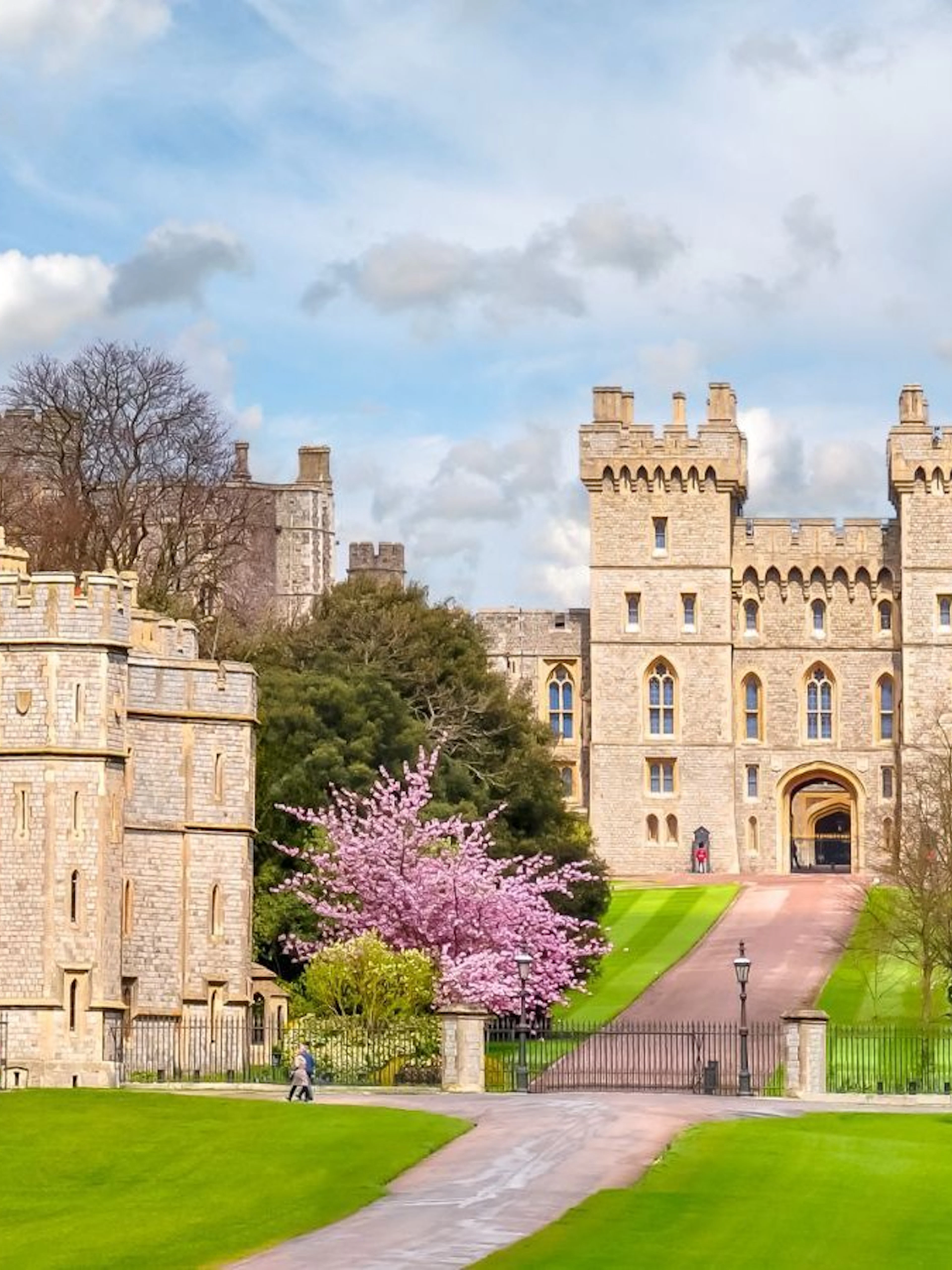 Windsor Castle entrance with lush gardens and historic architecture in England.