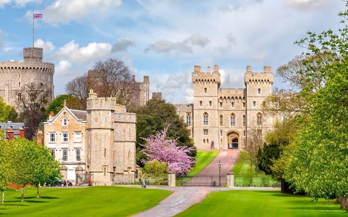 Windsor Castle entrance with lush gardens and historic architecture in England.