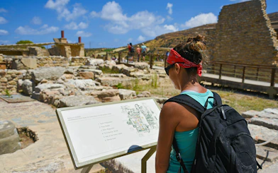 Woman reading map at Knossos Palace ruins, Crete, Greece.