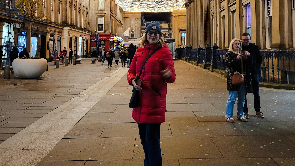 Guest walking on a lit street in Glasgow during the evening.