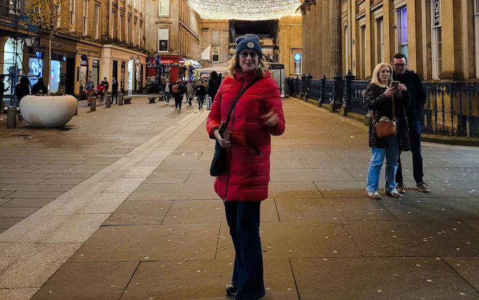Guest walking on a lit street in Glasgow during the evening.