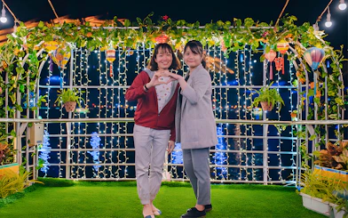 Couple on My Xuan Cruise, Han River, surrounded by lights and greenery at night.