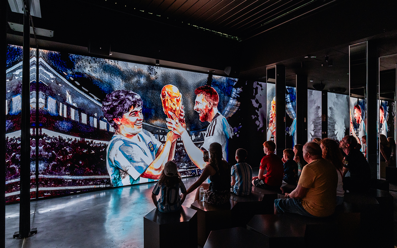 Football fans enjoying the LEGENDS tour, featuring a display of Messi's iconic moments, at the Home of Football museum
