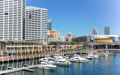 Boats docked at Darling Harbour with city skyline in Sydney.