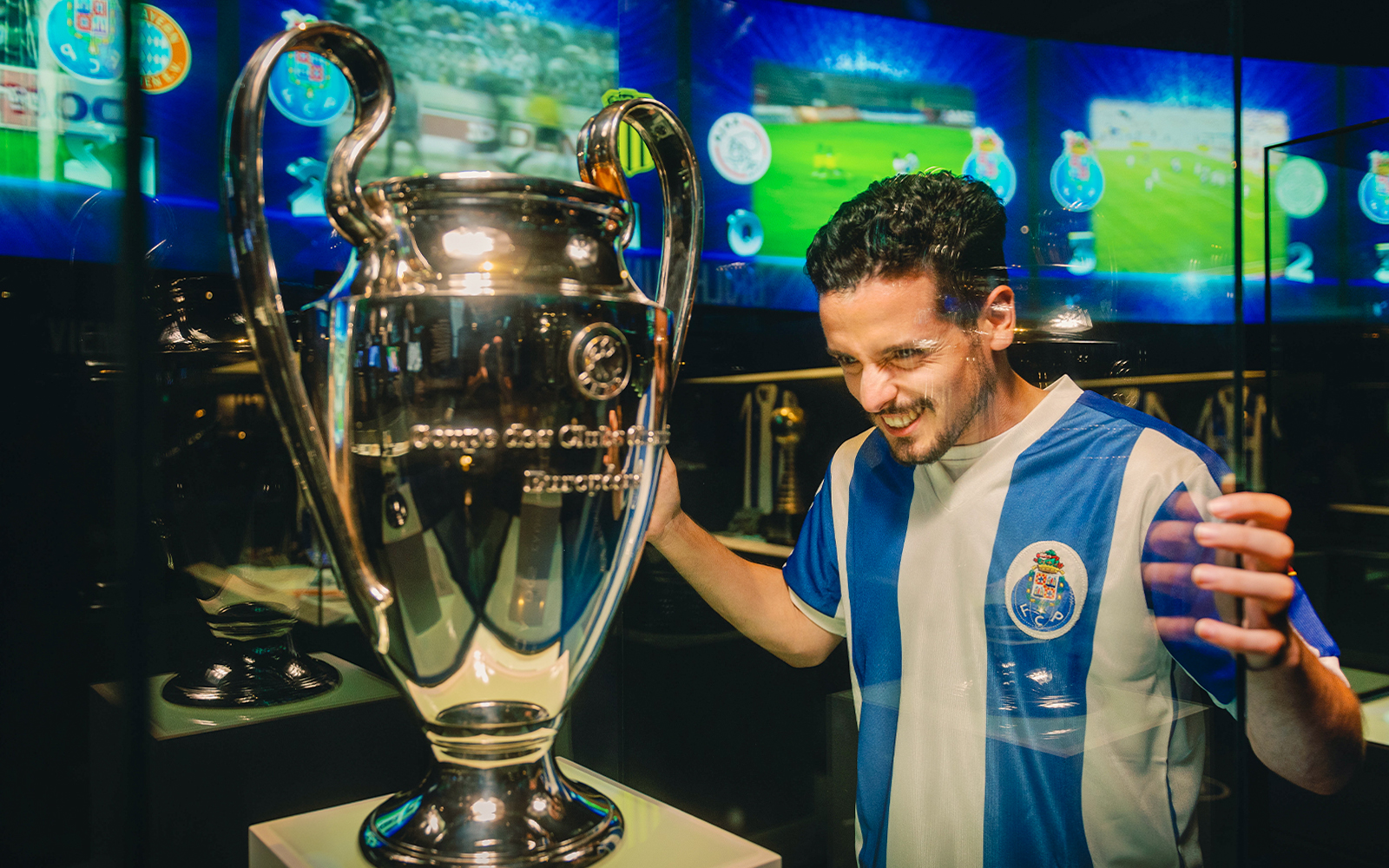 Visitor admiring trophy at FC Porto stadium museum.