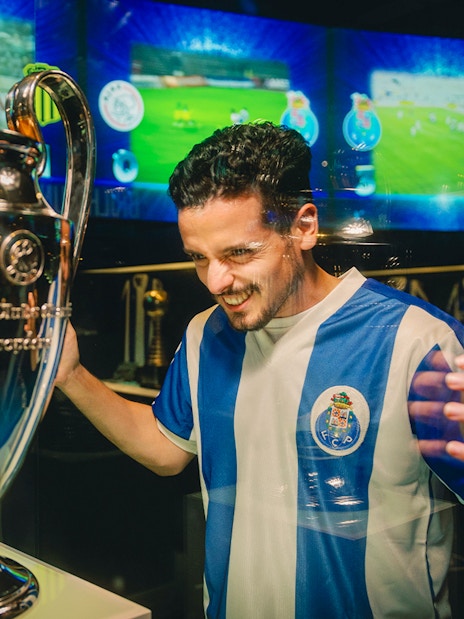 Visitor admiring trophy at FC Porto stadium museum.