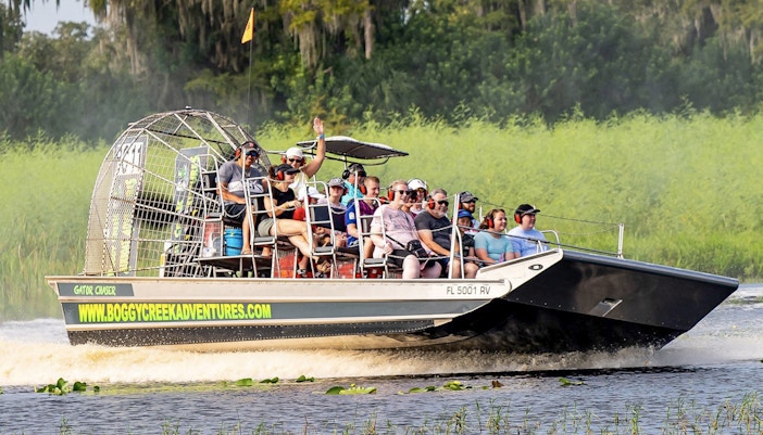 Guests on an airboat tour at Boggy Creek, Florida, enjoying the ride through wetlands.
