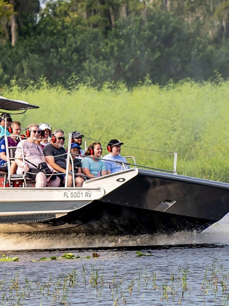 Guests on an airboat tour at Boggy Creek, Florida, enjoying the ride through wetlands.